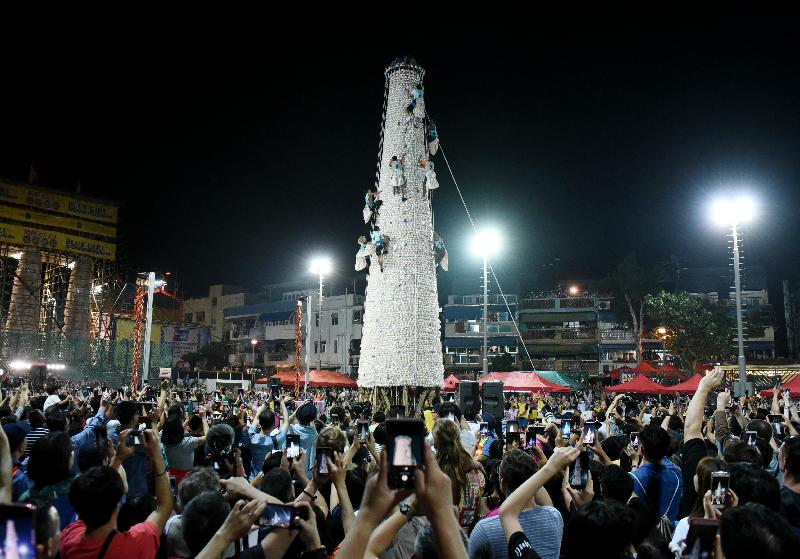 The Bun Scrambling Competition in Cheung Chau concluded early this morning (May 13). Photo shows the finalists scrambling up the bun tower to snatch as many buns as they can within a three-minute time limit to vie for the championships.