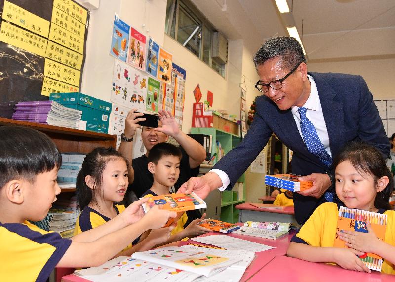 The Financial Secretary, Mr Paul Chan (second right), today (May 15) visited Fresh Fish Traders' School in Yau Tsim Mong District, where he is pictured distributing gifts to the students.  