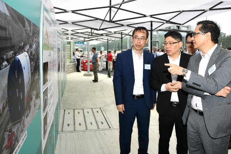 The Permanent Secretary for Development (Works), Mr Lam Sai-hung (centre), views exhibition panels before officiating at the Heung Yuen Wai Highway Opening Ceremony today (May 24).