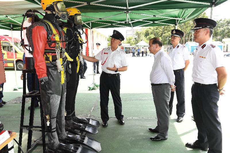 政务司司长张建宗（左二）今日（六月八日）下午到访沙田消防局。图示消防处的潜水组介绍一系列先进的水底救援工具。旁为消防处处长李建日（右一）。