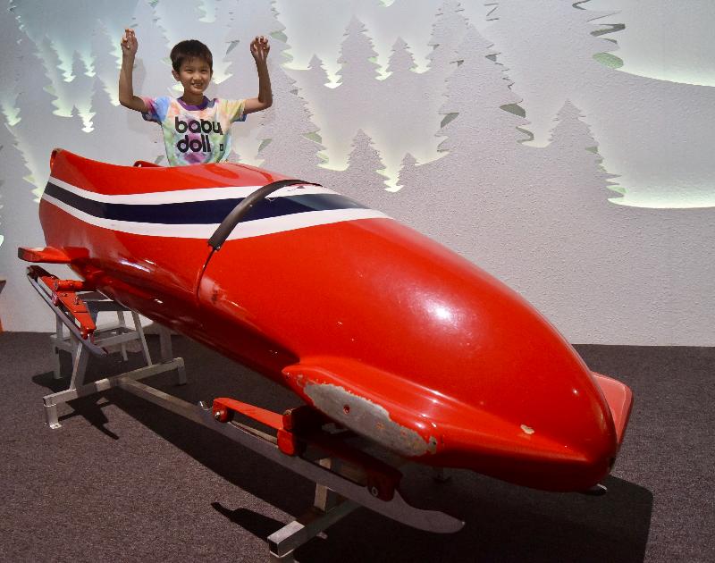 The Hong Kong Science Museum is holding a new exhibition entitled "Winter Games" from tomorrow (June 14) to October 16, offering visitors a glimpse of exciting winter sports and giving members of the public a taste what it feels like to be a winter sports athlete. Photo shows a young visitor enjoying photo-taking with a real bobsleigh at the exhibition.  