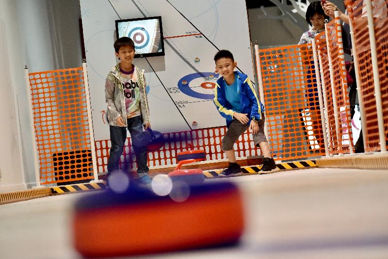 香港科學館明日（六月十四日）至十月十六日舉行全新展覽「冬季冰運會｣，把刺激的冬季運動帶到館中，讓市民一嘗做冬季運動員的樂趣。圖示參觀展覽的小朋友體驗滑行冰壺。