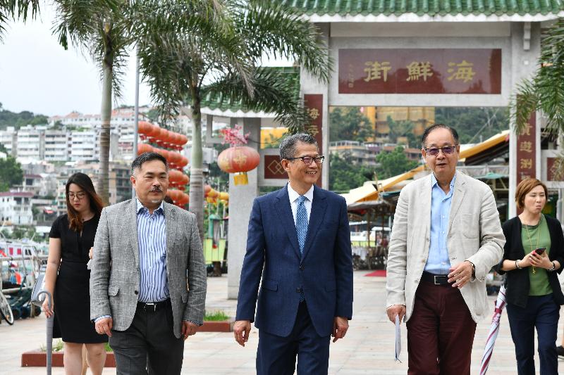 The Financial Secretary, Mr Paul Chan (centre), accompanied by the Chairman of the Sai Kung District Council, Mr George Ng (second right), and the District Officer (Sai Kung), Mr David Chiu (second left), this afternoon (June 25) visits Sai Kung Tai Street.