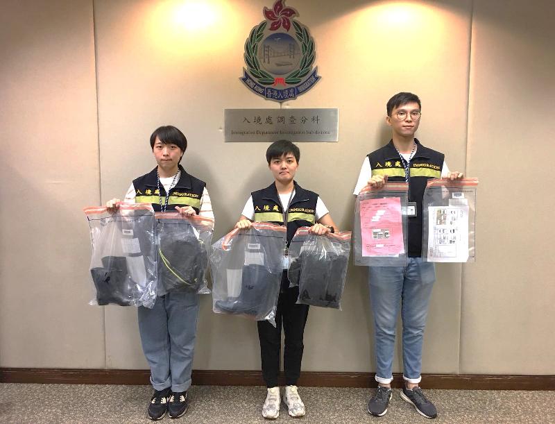 The Immigration Department mounted an anti-illegal worker operation codenamed "Twilight" on July 2 and 3 in Kowloon. Photo shows officers holding items seized during the operation.