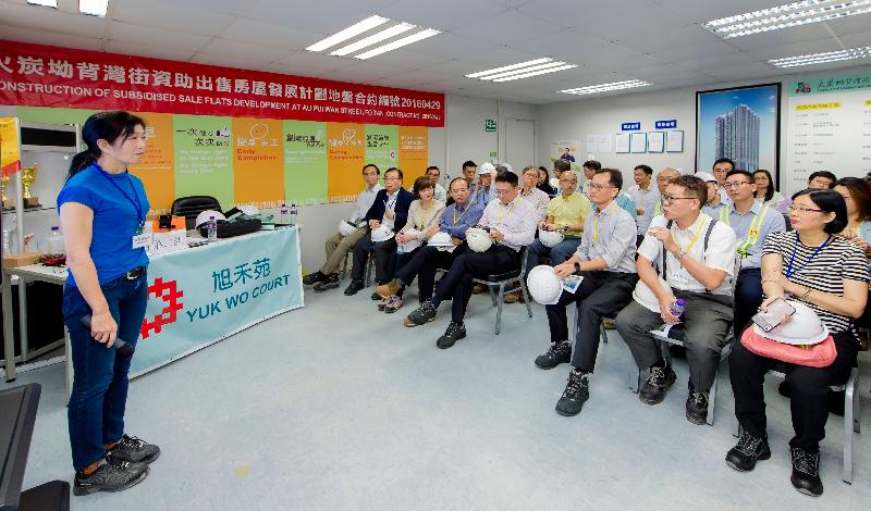 香港房屋委員會轄下建築小組委員會多名委員今日（七月二十五日）參觀沙田旭禾苑的工地。圖示小組委員聆聽房屋署代表簡報在各種限制下的地盤安全措施

