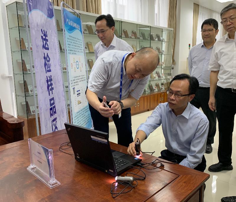 The Secretary for Constitutional and Mainland Affairs, Mr Patrick Nip, visited a standards and testing centre (STC) in Guangxi today (July 26). Photo shows Mr Nip (front row, first right) being briefed by an STC staff member on the equipment for testing wooden materials.