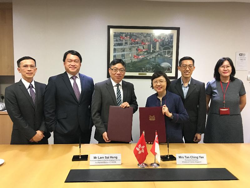 The Permanent Secretary for Development (Works), Mr Lam Sai-hung, and the Permanent Secretary of the Ministry of Finance of Singapore, Mrs Tan Ching-yee, sign a Memorandum of Understanding in Singapore today (July 30) to enhance collaboration in exchanging expertise and experience in infrastructure project management and delivery. Photo shows Mr Lam (third left); Mrs Tan (third right); representative of the Project Strategy and Governance Office of the Development Bureau, Mr John Kwong (second left); and the Executive Director of the Centre for Public Project Management of the Ministry of Finance of Singapore, Mr Chia Ser-huei (second right), at the signing ceremony.