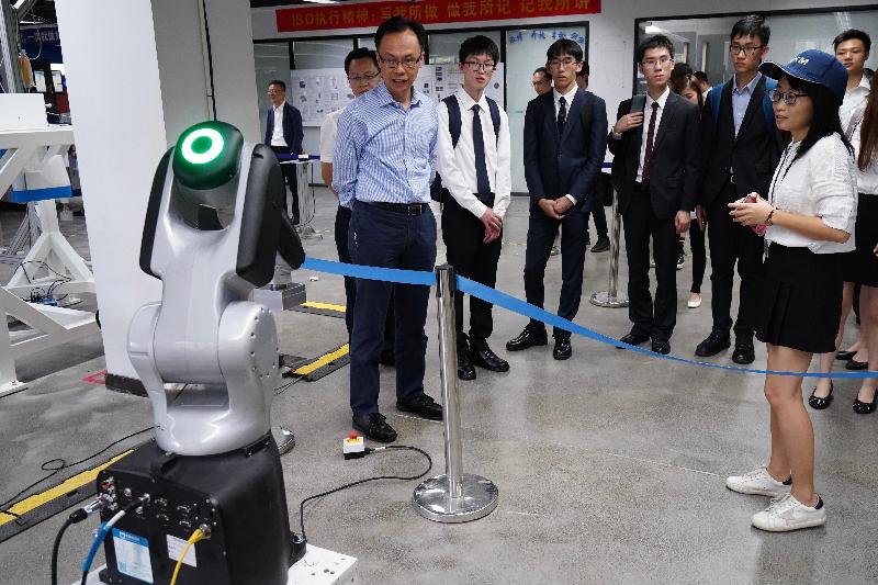 The Secretary for Constitutional and Mainland Affairs, Mr Patrick Nip, together with students, visited the Songshan Lake Xbot Park in Dongguan today (July 30). Photo shows Mr Nip (first left) being briefed on the operation of the robots.