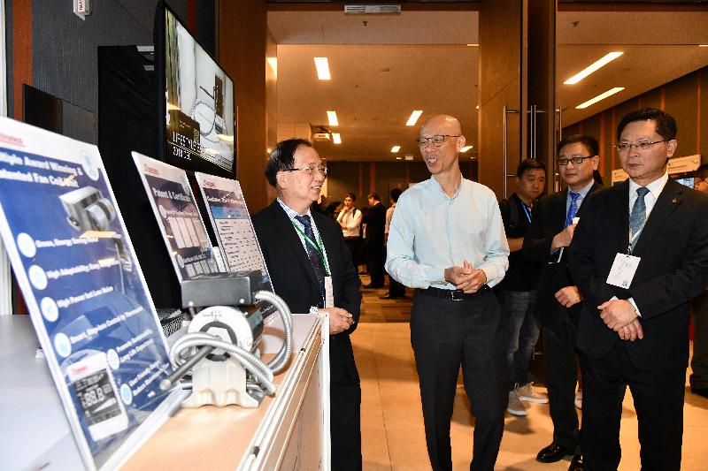 The Secretary for the Environment, Mr Wong Kam-sing (second left), tours an exhibitor's booth with the Director of Electrical and Mechanical Services, Mr Alfred Sit (first right), at the Green I&T Day organised by the Environment Bureau and the Electrical and Mechanical Services Department today (August 6).