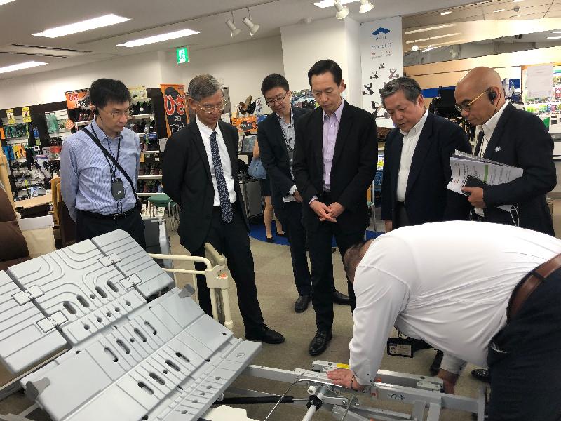 The Secretary for Labour and Welfare, Dr Law Chi-kwong, yesterday (August 6) visited a supplier of care equipment during his visit to Tokyo, Japan. Photo shows Dr Law (second left); the Chief Executive of the Hong Kong Council of Social Service (HKCSS), Mr Chua Hoi-wai (first left); and the Chairperson of the HKCSS, Mr Bernard Chan (fourth left), watching a demonstration on a size-adjustable care bed for elderly persons.