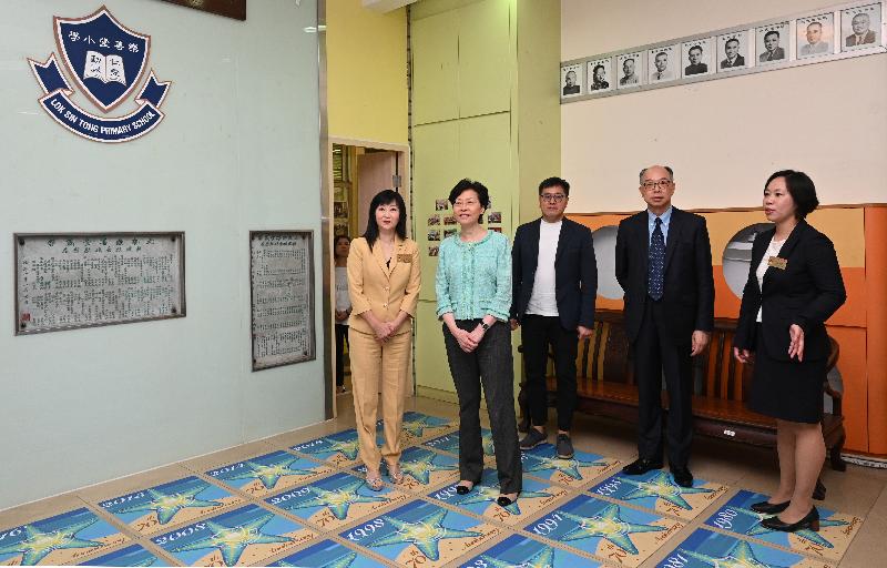 The Chief Executive, Mrs Carrie Lam, visited a transitional housing project operated by Lok Sin Tong in Kowloon City today (August 9). Photo shows Mrs Lam (second left), accompanied by the Secretary for Transport and Housing, Mr Frank Chan Fan (second right), visiting Lok Sin Tong Primary School to learn about the project to convert the school into transitional housing.