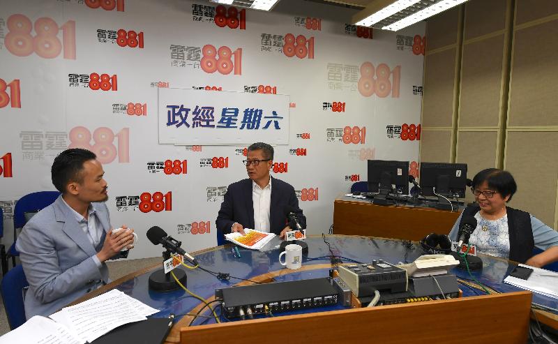財政司司長陳茂波（中）今早（八月十七日）出席商業電台節目「政經星期六」。