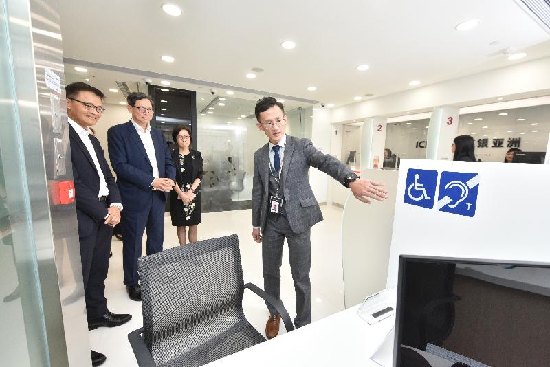 The Chief Executive of the Hong Kong Monetary Authority, Mr Norman Chan (second left), and the Chairman and Executive Director of the Industrial and Commercial Bank of China (Asia), Ms Gao Ming (second right), visits a recently opened bank branch in Tsui Lam Estate in Tseung Kwan O today (September 12).