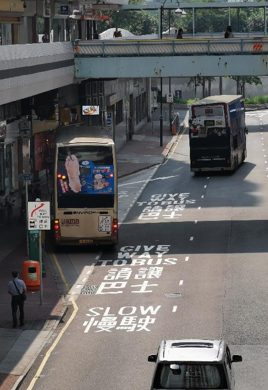 The Transport Department today (September 19) has introduced a bus-friendly traffic measure to encourage motorists to let buses exit more easily from bus bays to adjacent traffic lanes and thereby make bus services more smooth. Photo shows the "Give way to bus" traffic sign and "Slow" and "Give way to bus" road markings at the first trial site - a bus stop at Wang Pok Street outside Lucky Plaza in Sha Tin and the label with the "Give way to bus" sign stuck on the back of a bus.