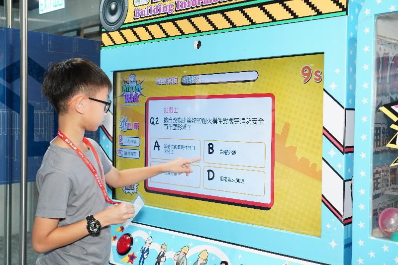A kid plays interactive video games at the award presentation ceremony of a postcard design competition with the theme "Living in Safe Buildings" today (October 26).
