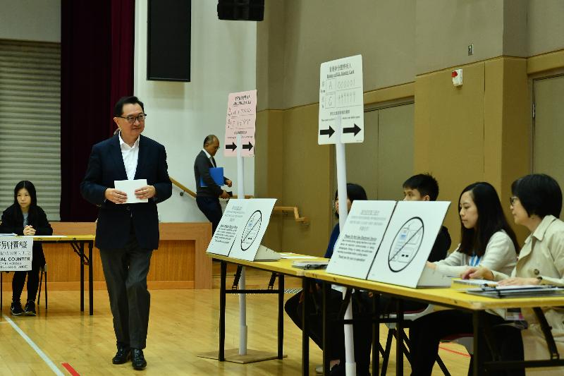The Chairman of the Electoral Affairs Commission, Mr Justice Barnabas Fung Wah (second left), demonstrates the proper procedure to cast votes in the District Council Ordinary Election during his visit to a mock polling station at Leighton Hill Community Hall today (November 19).