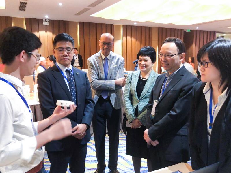 政府資訊科技總監林偉喬（右二）十一月二十一日在越南下龍舉行的第十九屆亞太資訊及通訊科技大獎「香港之夜」活動上聽取香港代表介紹其創新作品。

