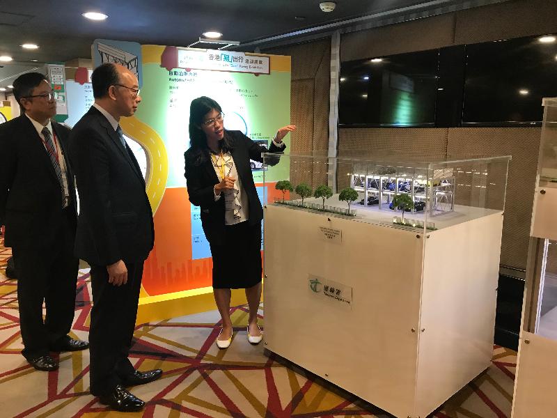 The Secretary for Transport and Housing, Mr Frank Chan Fan, today (December 3) attended the International Symposium on Road Congestion Charging. Photo shows Mr Chan (centre) viewing a model of an automated parking system.
