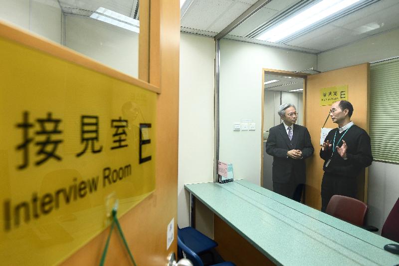 公務員事務局局長羅智光今日（十二月五日）到訪法律援助署。圖示羅智光（左）在刑事組的接見室聽取同事介紹「遙距公事探訪系統」的運作情況。
