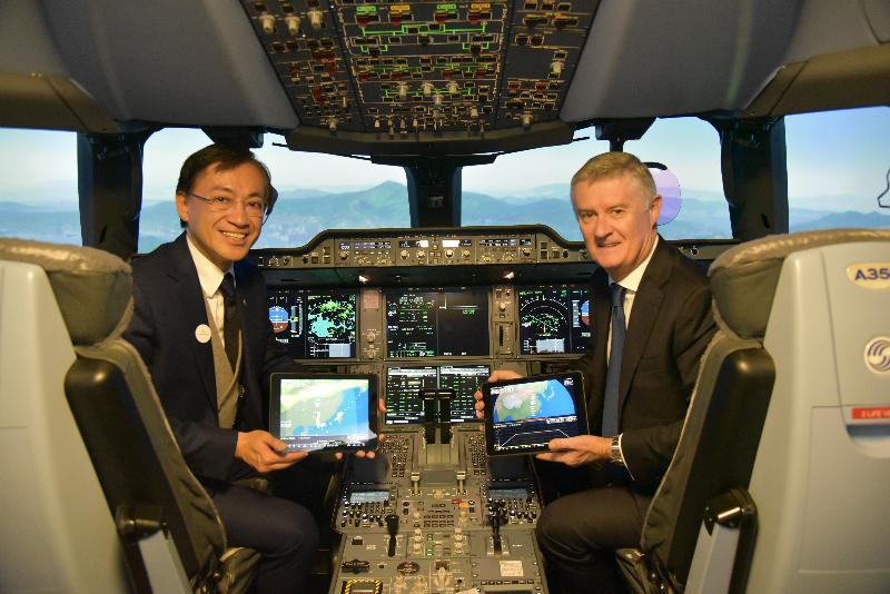 The Hong Kong Observatory (HKO) announced today (December 9) that its electronic flight bag weather mobile application "MyFlightWx" has officially commenced operation in both Cathay Pacific and Cathay Dragon flights. Photo shows the Director of the HKO, Mr Shun (left) and the Chief Operations and Service Delivery Officer of Cathay Pacific Airways, Mr Greg Hughes, showcasing the mobile application "MyFlightWx" in a flight simulator. 
