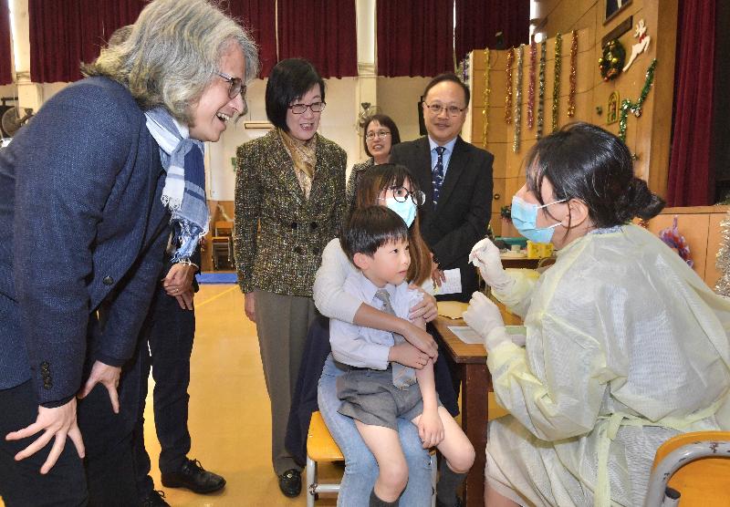 衞生署署長陳漢儀醫生（左二）今日（十二月十三日）到訪保良局陳守仁小學，視察署方為該校安排的外展疫苗接種活動。