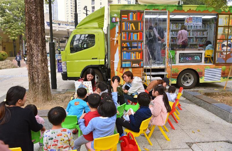 康樂及文化事務署香港公共圖書館明年一月推出「樂在社區閱繽紛──『喜』動圖書館」試驗計劃，推廣全民閱讀。「喜」動圖書館已在各區試行，圖示故事大使於星期日給小朋友講故事。