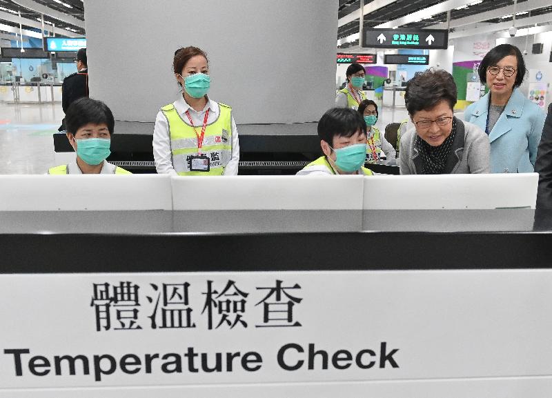 The Chief Executive, Mrs Carrie Lam, today (January 3) visited the West Kowloon Station of the Guangzhou-Shenzhen-Hong Kong Express Rail Link to inspect the prevention measures adopted at the boundary control point in response to the cluster of pneumonia cases detected in Wuhan, Hubei Province. Photo shows Mrs Lam (second right), accompanied by the Secretary for Food and Health, Professor Sophia Chan (first right), inspecting the checking of body temperatures of inbound travellers by officers of the Port Health Division. 