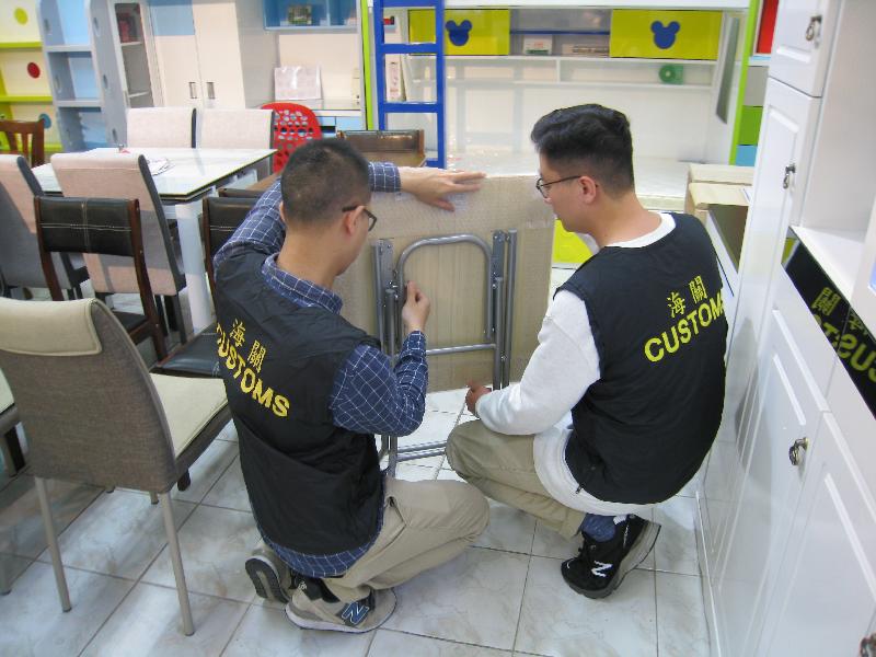 香港海關一月七日至今日（一月十日）於全港進行特別行動，巡查80個出售摺枱及摺椅產品的零售點，並與業界代表會面，確保市面出售的摺枱及摺椅產品符合《消費品安全條例》的規定。圖示巡查人員於零售點即場檢視摺枱的鎖定裝置。