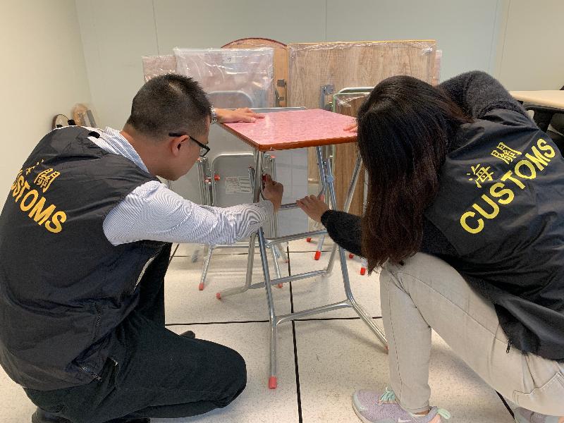 Hong Kong Customs has conducted a special operation, starting on January 7 and concluding today (January 10), during which inspections of folding table and chair products were made at 80 retailing shops across the territory. Meetings with trade representatives were also held to ensure the sector's compliance with the Consumer Goods Safety Ordinance. Photo shows inspection officers checking the availability of locking devices on different folding table and chair products.