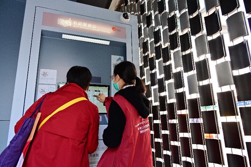 The Hong Kong Public Libraries of the Leisure and Cultural Services Department launched the third self-service library station today (January 15) in Tai Wai, strengthening the provision of round-the-clock public library services. Photo shows a library ambassador offering help to the public at the new library station.