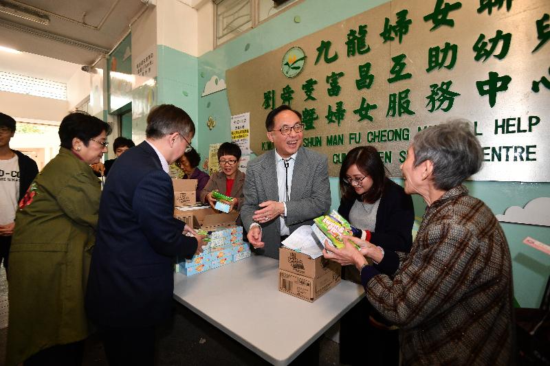 The Secretary for Innovation and Technology, Mr Nicholas W Yang (third right), and the Under Secretary for Innovation and Technology, Dr David Chung (second left), team up with volunteers today (January 17) to distribute sweets to the elderly and the needy to ring in the Lunar New Year.