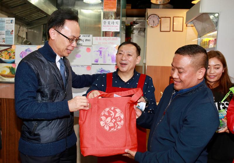 The Secretary for Constitutional and Mainland Affairs, Mr Patrick Nip, visited a restaurant run by ethnic minorities in Yau Tsim Mong District today (January 17). Photo shows Mr Nip (left) presenting the shop-owner with a Chinese New Year gift pack.