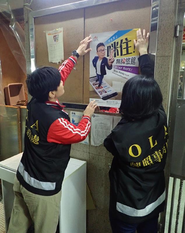 The Office of the Licensing Authority (OLA) of the Home Affairs Department stepped up enforcement actions against unlicensed guesthouses during the Christmas and New Year holidays. Photo shows OLA officers placing posters in the lobby of a residential block to remind visitors not to stay at unlicensed guesthouses.