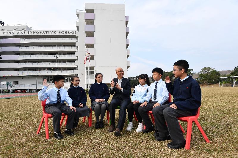 环境局局长黄锦星（中）昨日（一月二十日）到访上水凤溪创新小学，与学生分享减缓气候变化的个人及校园经验。