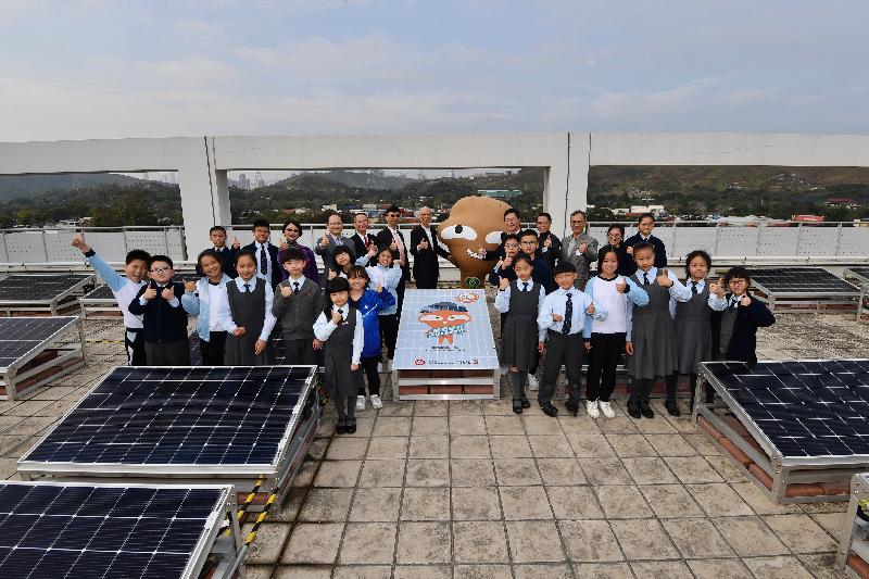 The Secretary for the Environment, Mr Wong Kam-sing, visited Fung Kai Innovative School in Sheung Shui yesterday (January 20) to view the solar panels installed at the school rooftop. Picture shows Mr Wong (back row, seventh left) with guests, teachers and students as well as Hanson at the rooftop.