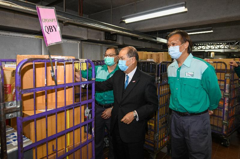 政務司司長張建宗（中）今日（二月十七日）到訪香港郵政，視察處理內載口罩的特快專遞郵件流程。


