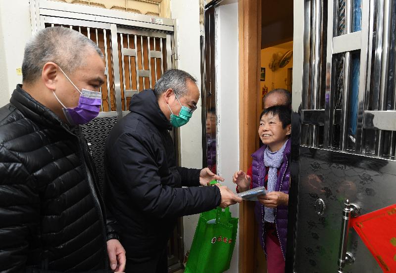 民政事務局局長劉江華（中）今日（二月十七日）到訪居於旺角的市民，為他們送上包括口罩的抗疫用品。
