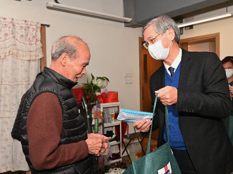 The Secretary for Labour and Welfare, Dr Law Chi-kwong (right), went to Tai Kok Tsui this evening (February 17) to present elderly persons with face masks and anti-epidemic gift packs (fortune bags).