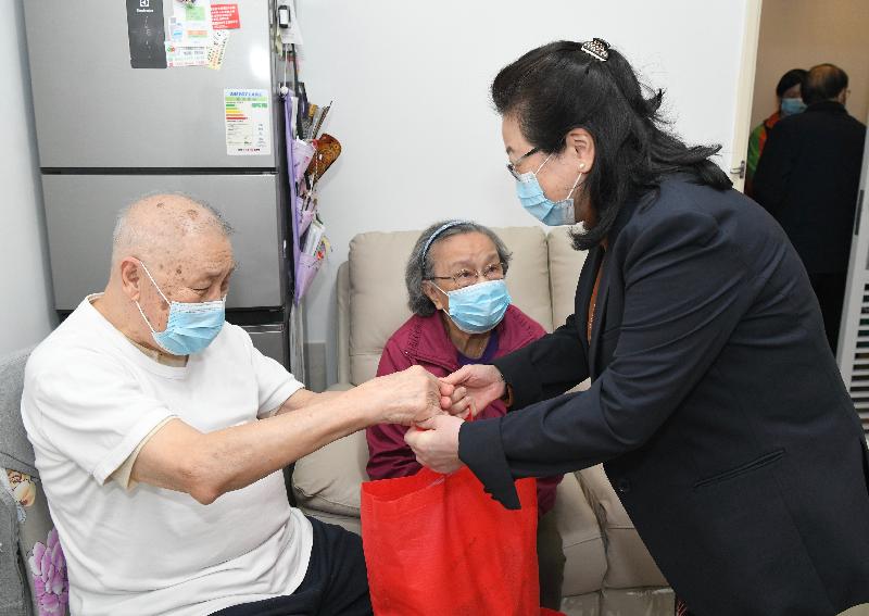 The Secretary for Justice, Ms Teresa Cheng, SC (right), visits elderly families in Long Shin Estate at Yuen Long today (February 18) to distribute surgical masks, food, leaflets with health information and other goods to them. 