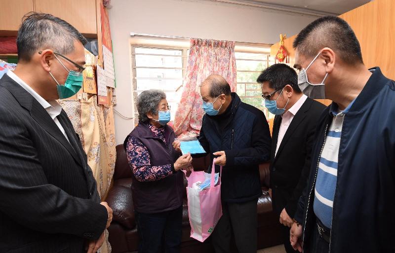 政務司司長張建宗（中）今日（二月二十二日）在東區民政事務專員陳尚文（左一）陪同下到訪北角健康村，向長者派發口罩等抗疫物資。

