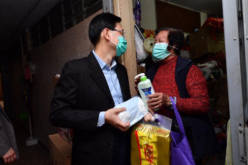 The Secretary for Security, Mr John Lee (left), visited Yiu On Estate in Ma On Shan this afternoon (February 25) to distribute surgical masks, alcohol-based hand rub and other daily necessities to the elderly.