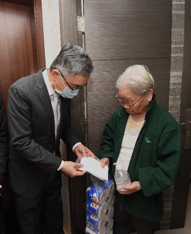 The Secretary for Financial Services and the Treasury, Mr James Lau, visited elderly in Central and Western District today (February 28). Photo shows Mr Lau (left) giving an elderly person anti-epidemic items including surgical masks.