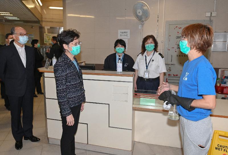 The Chief Executive, Mrs Carrie Lam (second left) visited Cheung Hong Estate in Tsing Yi today (March 4) to inspect Hong Mei House where confirmed cases involving residents of units on different floors were reported earlier. She also met with personnel of the Housing Department, the Home Affairs Department and the Police to thank them for their tireless efforts in doing follow-up work to safeguard public health. Photo shows Mrs Lam and the Secretary for Transport and Housing, Mr Frank Chan Fan (first left), chatting with security workers and a cleaning worker at the ground floor lobby of Hong Mei House.