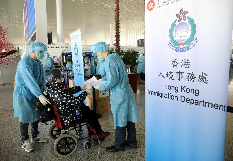 入境事務處（入境處）人員今日（三月五日）在武漢天河國際機場，協助滯留在湖北省的港人登上專機返港。圖示入境處人員為一名需輪椅輔助的人士登記資料。