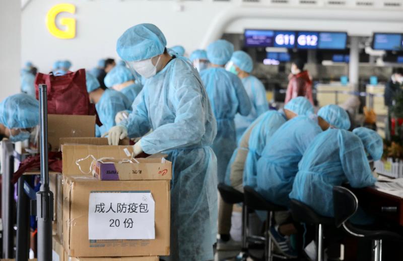 After arrival at the Wuhan Tianhe International Airport this morning (March 5), staff members of the Immigration Department starts preparing for the registration of the stranded Hong Kong residents who will take the chartered flight back to Hong Kong. Photo shows them unpacking the anti-epidemic packs for distribution to the passengers.