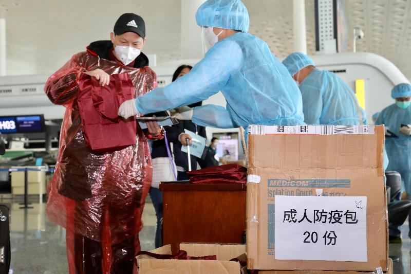 Immigration Department staff today (March 5) distributes anti-epidemic packs at the Wuhan Tianhe International Airport to stranded Hong Kong residents who will take the chartered flight back to Hong Kong. The anti-epidemic packs contain personal protective equipment, masks, alcoholic pads and health advice information.