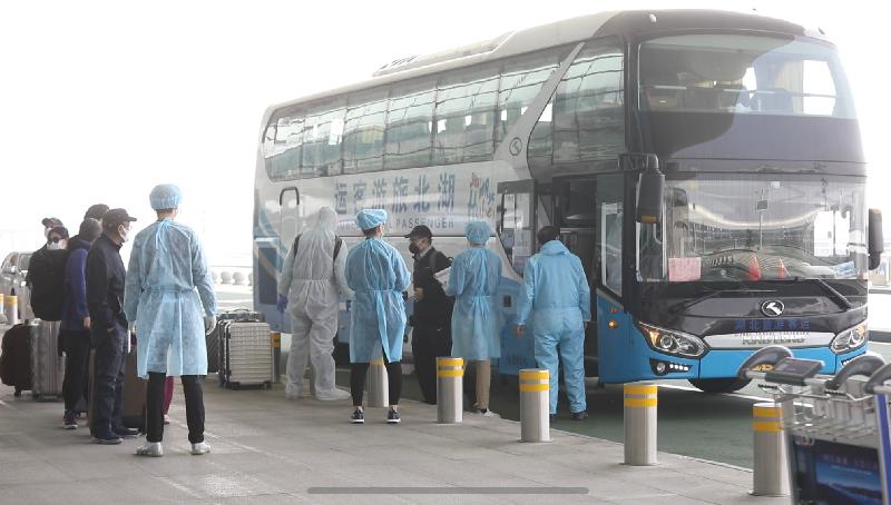 Hong Kong residents stranded in Hubei Province disembark from a coach at the Wuhan Tianhe International Airport today (March 5) to board the chartered flight to Hong Kong.