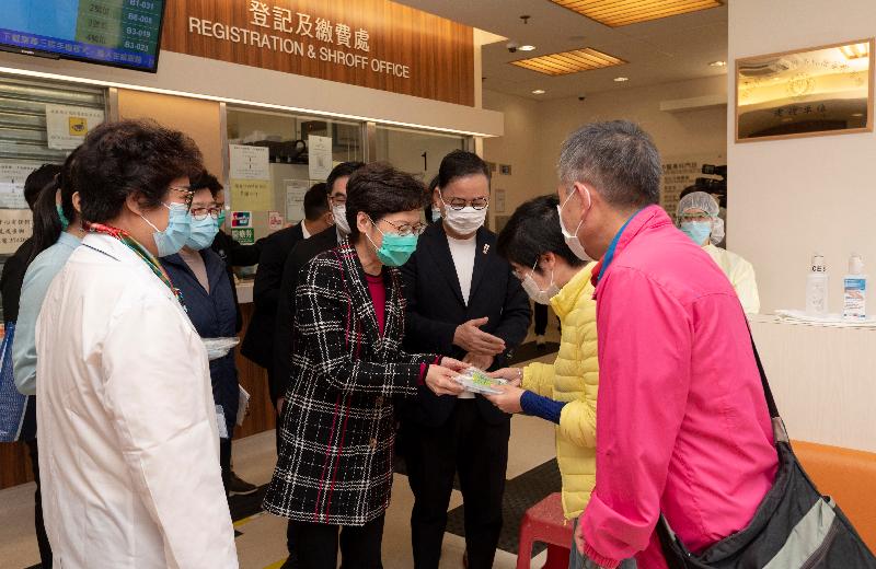 The Chief Executive, Mrs Carrie Lam (fourth right), visited a Chinese medicine clinic of the Tung Wah Group of Hospitals in Yau Ma Tei this afternoon (March 11). Photo shows Mrs Lam chatting with clients of the clinic and distributing face masks and other anti-epidemic supplies to them.