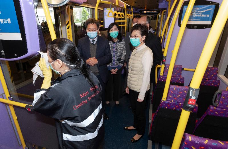 The Chief Executive, Mrs Carrie Lam, visited bus captains at the North Point Ferry Pier Public Transport Interchange and staff of the Lands Department in the same district this afternoon (March 13) to express her gratitude for their tireless efforts in their respective posts amid the epidemic to fight the disease together. Photo shows Mrs Lam (first right), accompanied by the Commissioner for Transport, Ms Mable Chan (second right), viewing the enhanced cleaning and sterilisation of a bus compartment by a cleaning worker.