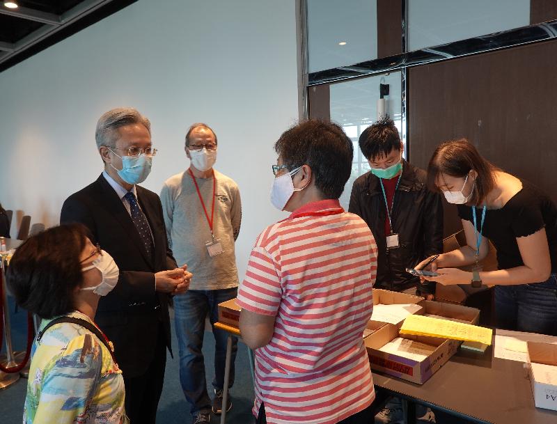 公務員事務局局長羅智光（左二）今日（三月二十三日）到訪政府資訊科技總監辦公室位於香港大會堂的家居檢疫控制中心，關心同事應對強制家居檢疫人數增加的工作情況。

